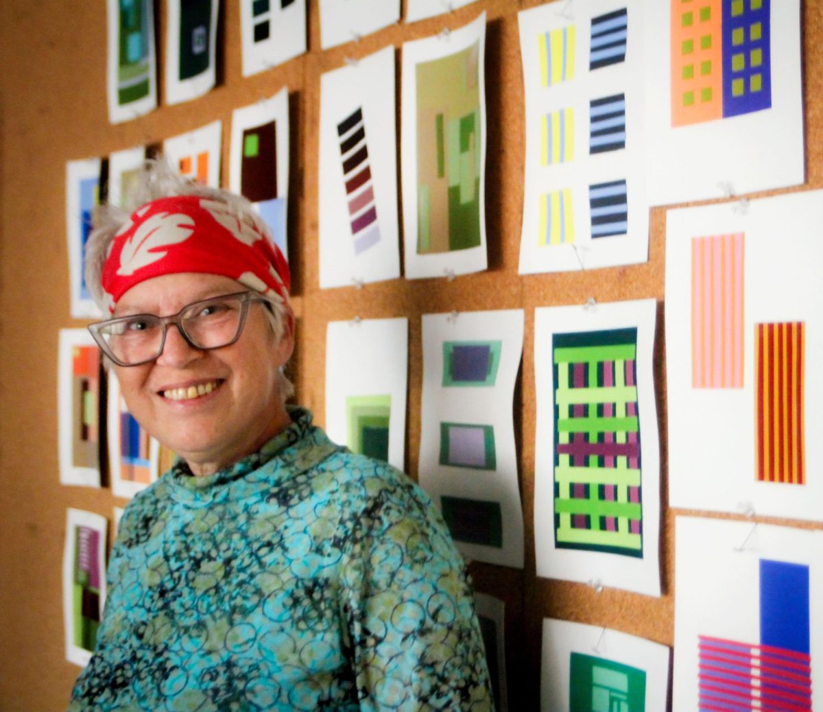 Molly Alter, full-time art professor at John A. Logan College, stands beside student color theory projects in her classroom Oct. 21. Alter has taught at the college since 2012 and encourages her students to embrace creativity and learn through mistakes
