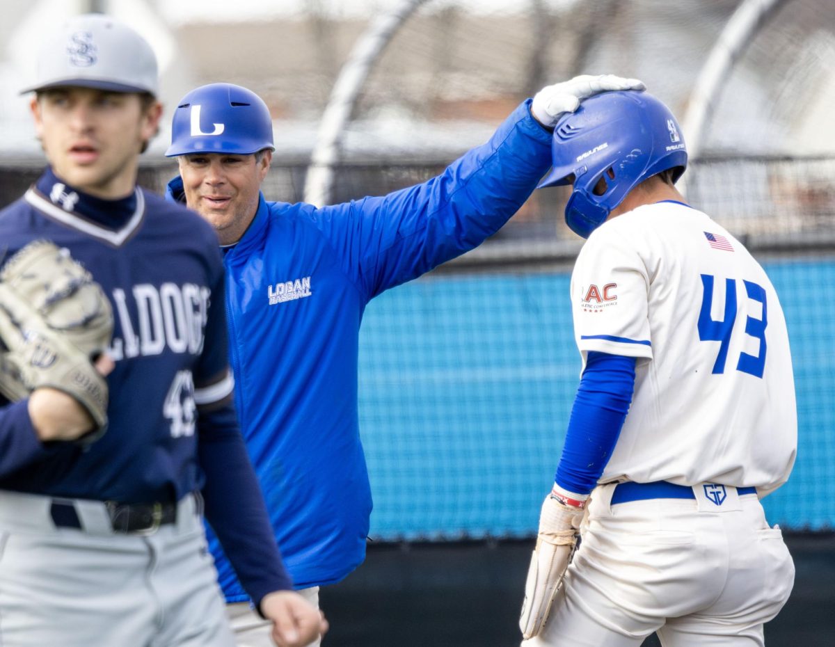 John A. Logan coach Kyle Surprenant taps Justin Lang on the helmet near the dugout during a game against South Suburban College Feb. 21, 2026, in Carterville. Lang finished 2-for-3 with a run scored in Logan’s 12-2 win. 
