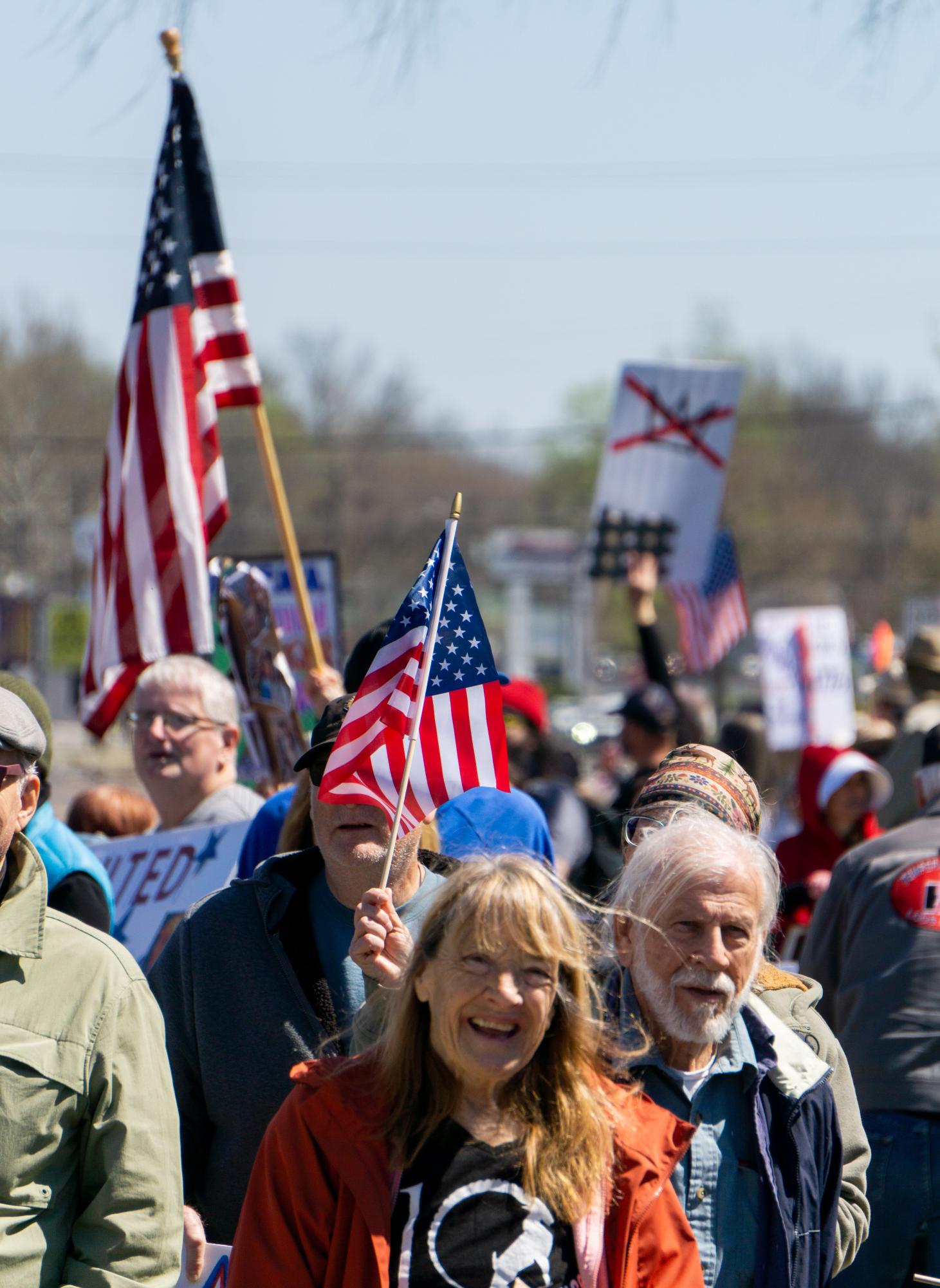 Demonstrators hold signs during the No Kings protest at Turley Park in Carbondale, Ill., March 28, 2026.