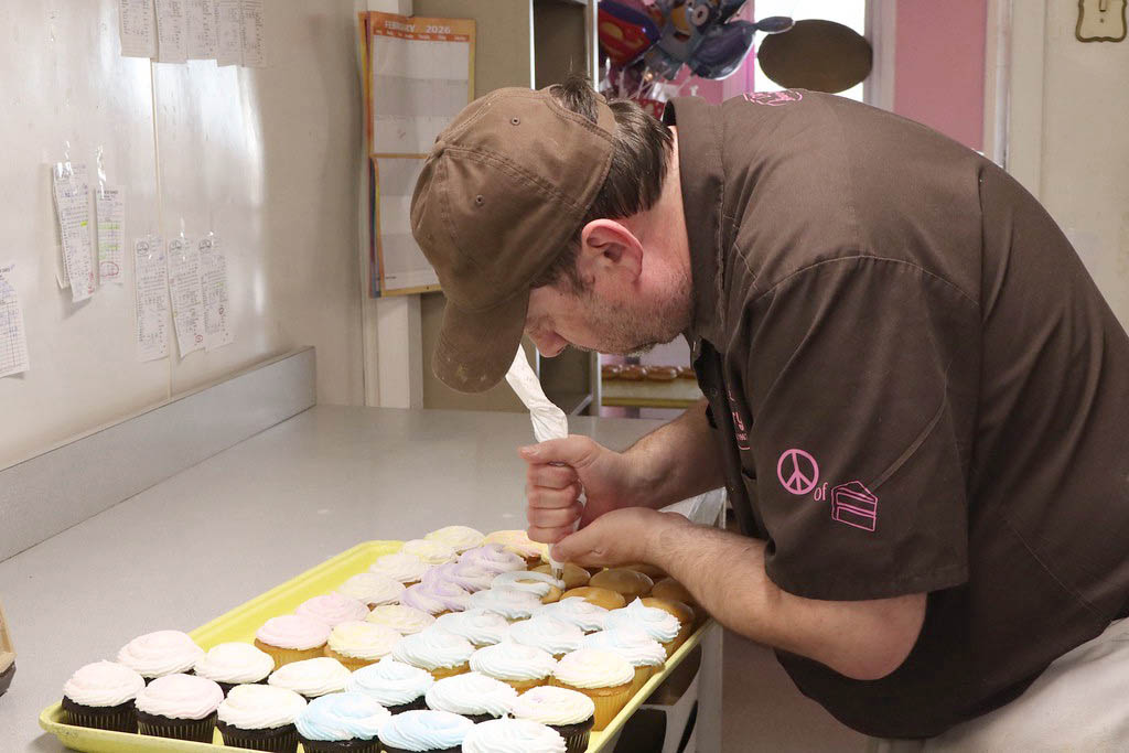 David Clayton, manager of Larry’s House of Cakes, ices cupcakes Feb. 16, 2026, at the bakery in Marion, Ill. 